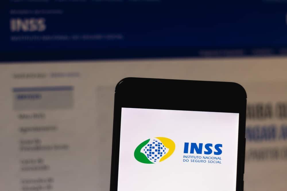 celular com logo da home page do INSS
