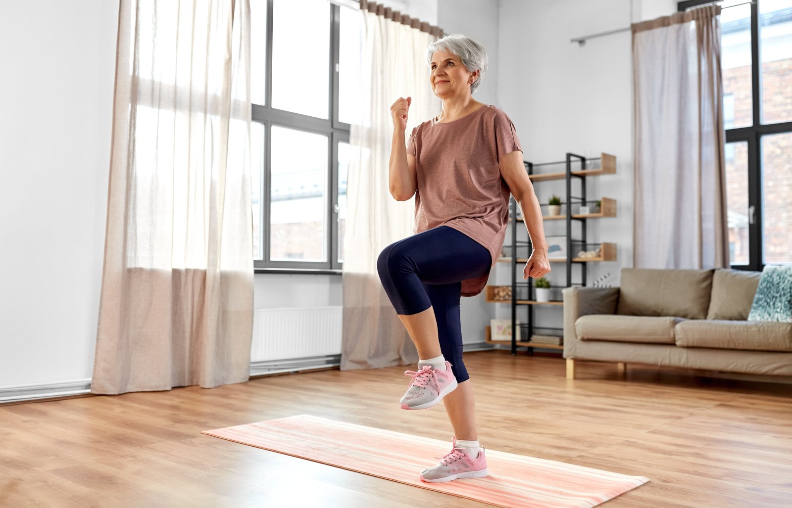 sport, fitness and healthy lifestyle concept - smiling senior woman exercising on mat and walking on spot at homeWEBSTORY HABITO EXERCÍCIOS